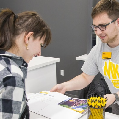 Student employee helping a new UWM student in the welcome center.