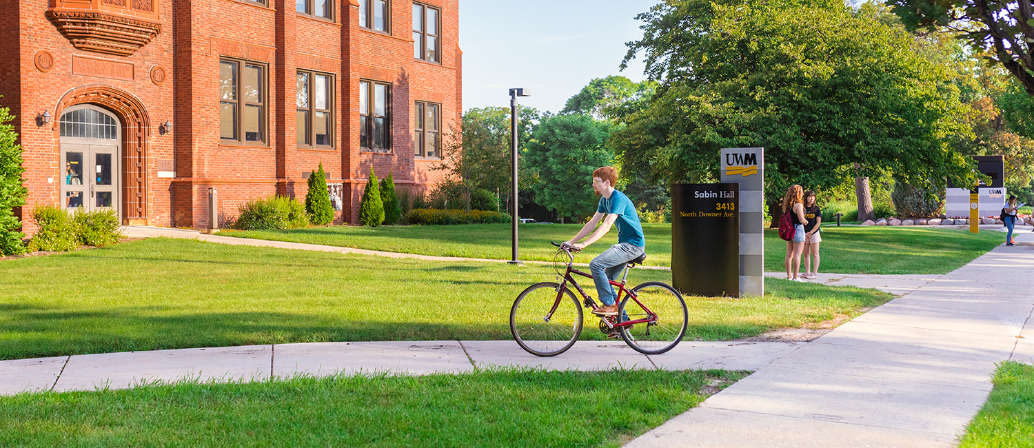 学生骑自行车穿过萨宾大厅附近的校园