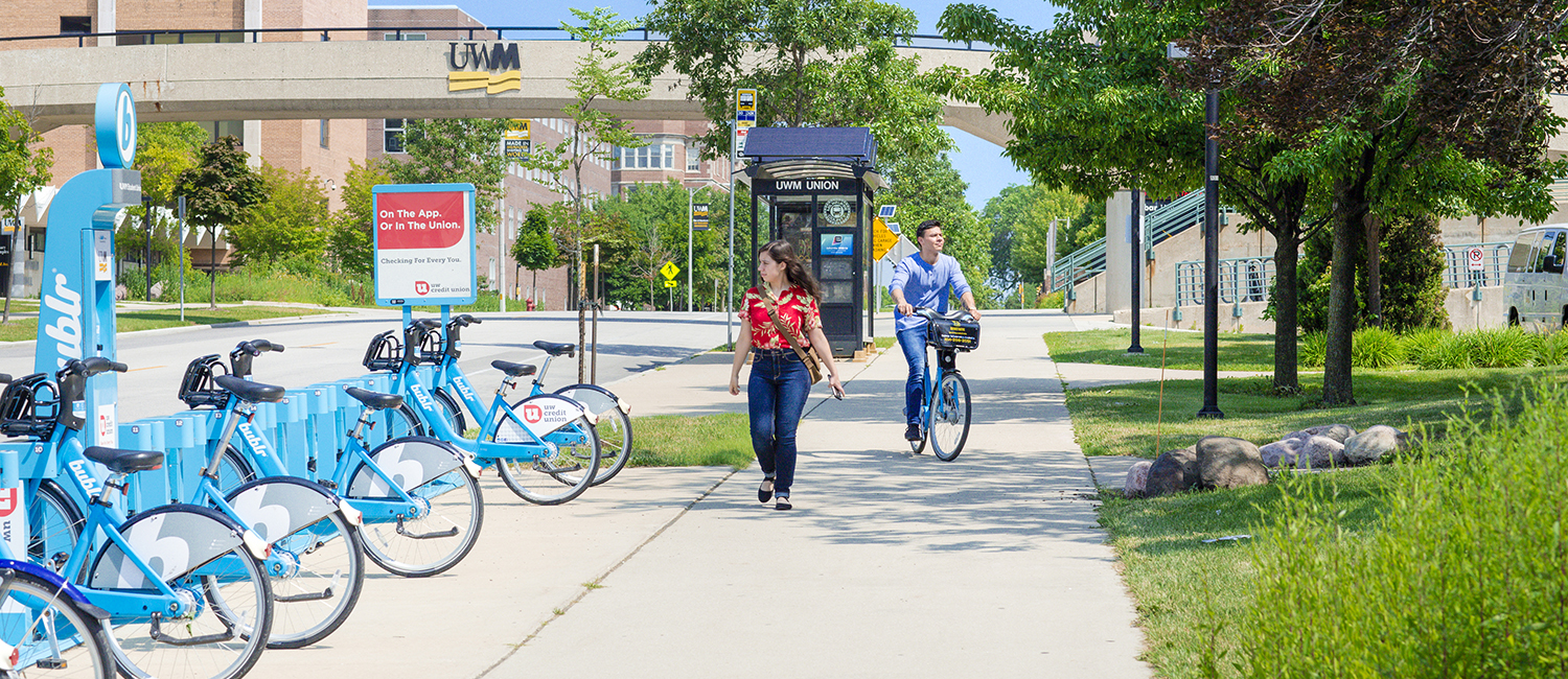 Student walking through campus and another on a Bublr bike