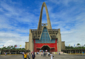 红色和蓝色的建筑有高高的中心拱门，人们在周围走动