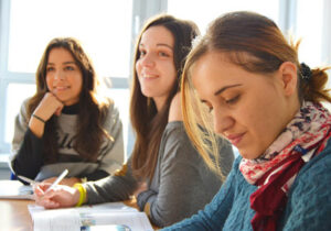 三个女学生坐在教室的窗户前