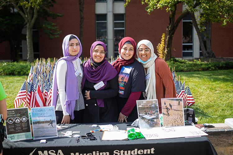 四名威斯康beplay客服有没有电话辛大学穆斯林学生站在穆斯林学生协会的桌子旁